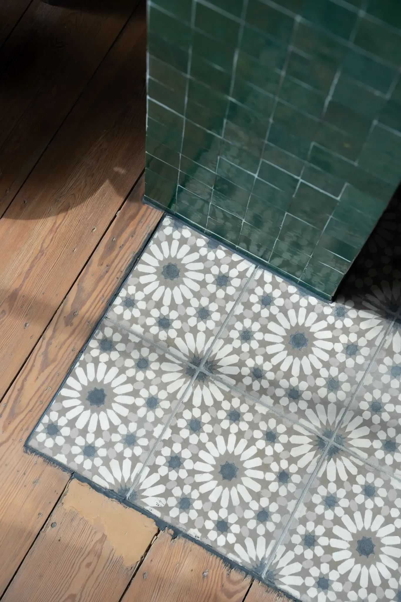 Fuoco — raccordo tra camino verde, pavimento a motivi e parquet in legno