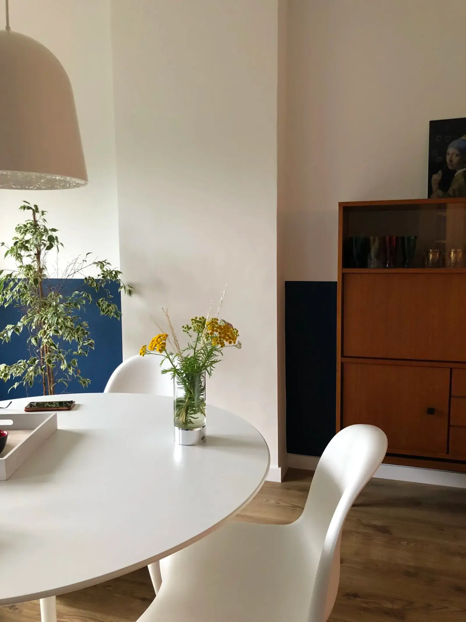 Rive Gauche — zona pranzo, tavolo rotondo bianco e credenza vintage in teak