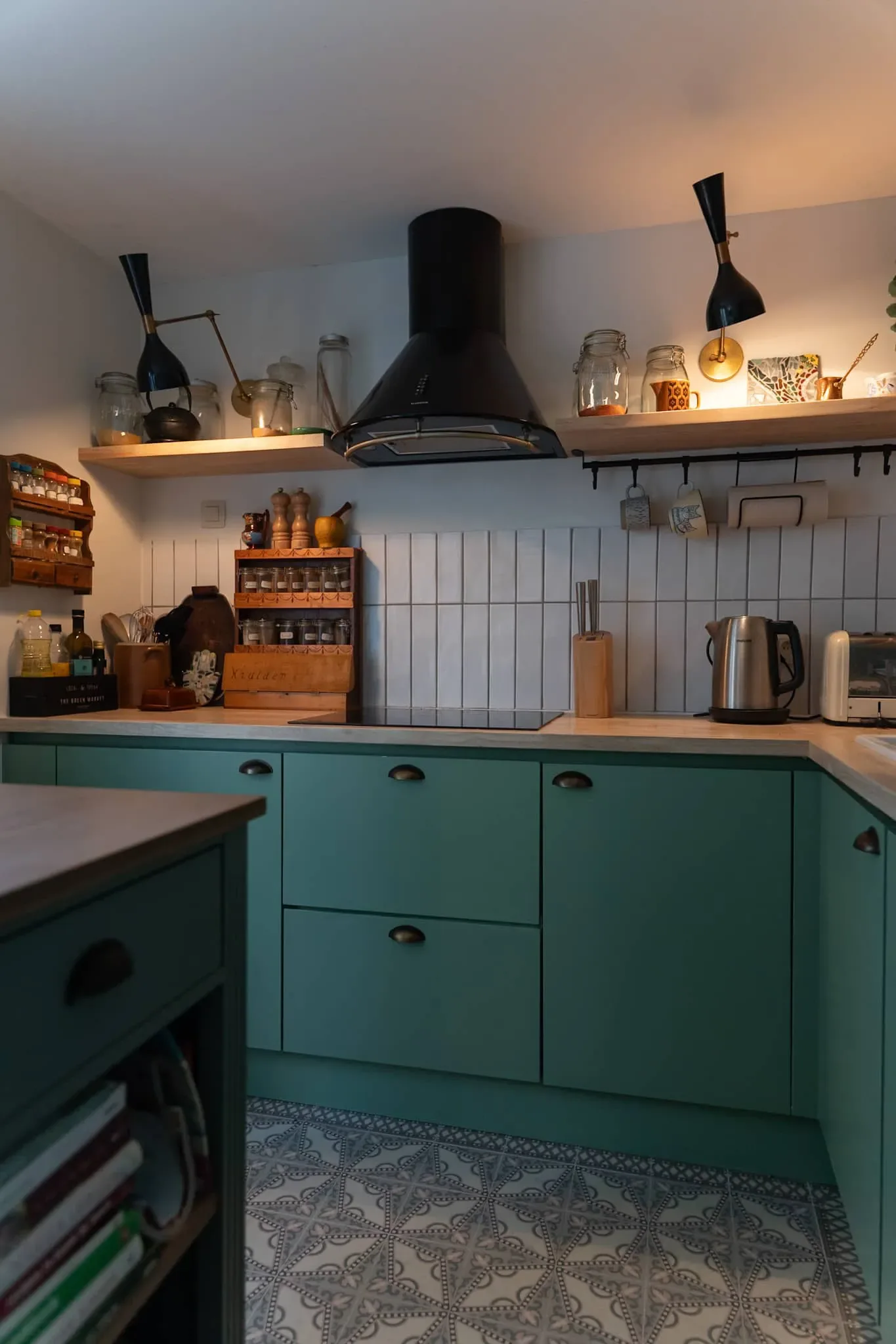 Schaerbeek — sage-green kitchen, black extractor hood and wall lights