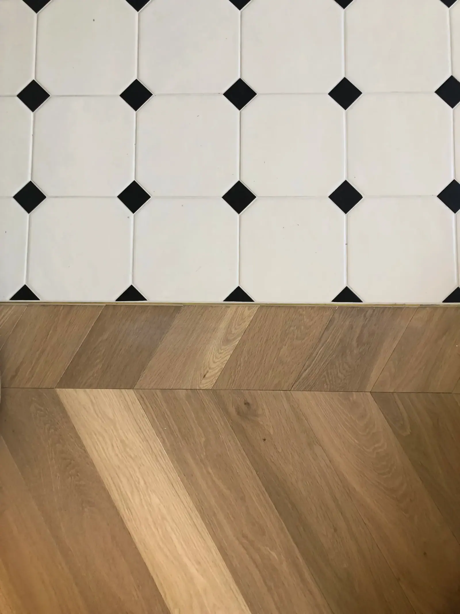 Sterrebeek — raccordo tra pavimento a scacchi bianco e nero e parquet a spina di pesce, dettaglio